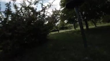 Bu, arka planda yemyeşil ağaçlar ve konut binaları olan bir şehir parkının havadan görüntüsü. Park şehrin yoğun bir bölgesinde yer almaktadır, ama huzurlu ve rahatlatıcı bir yer sunar.