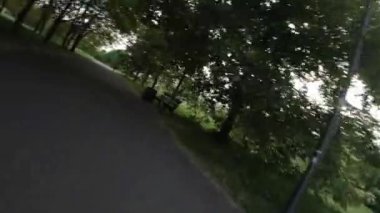 Muhteşem bir parkta sakin bir yolculukta bize katılın. Video bereketli yeşillikler arasında pürüzsüz bir yolculuk içeriyor, mavi gökyüzünün parıldayan ağaçların arasından süzülüşünü gösteriyor. Parklar asfaltlandı.