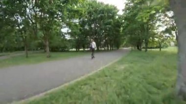 Bu, parkta sakin bir yürüyüşün videosu. Video, parklarda asfalt yolda yürüyen bir kişinin perspektifinden çekildi. Park yemyeşil ağaçlar ve çeşitli bitkilerle dolu.