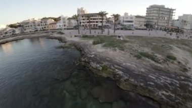 Bu çarpıcı hava görüntülerinde büyüleyici kıyı şeridi boyunca yerleşmiş olan Akdeniz köyü Village Name sergileniyor. Köylerin geleneksel mimarisi, beyazlatılmış.