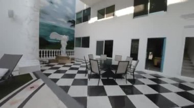 Bu video, açık kat planına sahip çarpıcı bir minimalist ev sergiliyor. Video, temiz çizgileri ve modern tasarımıyla karakterize edilen evlerin dış görünüşü ile başlıyor.