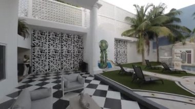 Videoda havuzu ve duvarları olan güzel bir avlu var. Avlu renkli duvar resimleriyle süslenmiş ve siyah beyaz kareli zemini var. Havuz yemyeşil ve yemyeşil ile çevrili.