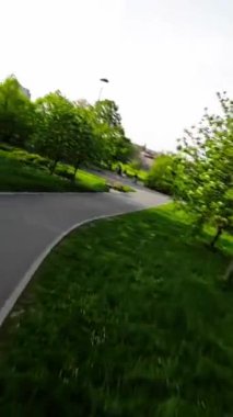 Huzur dolu bir parkın bu büyüleyici videosuyla kendinizi doğanın sükunetine bırakın. Bereketli yeşil ağaçlar ve canlı çiçekler rahatlatıcı bir yürüyüş için pitoresk bir ortam yaratır. Hafif bir esinti