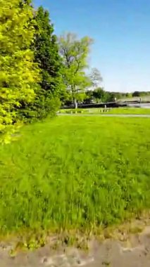 Sizi güzel bir parkta huzurlu bir yolculuğa çıkaran bu büyüleyici videoyla kendinizi doğanın sakinliğine daldırın. Bereketli yeşil ağaçlar, canlı çiçekler ve sakin su.