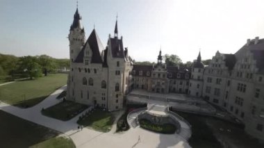 Video, Polonya 'daki bir kalenin nefes kesici hava görüntüsüyle açılıyor. Kale yemyeşil ağaçlar ve sakin bir nehirle çevrili ve manzaralı bir manzara yaratıyor. Bu video bizi daha sonra...