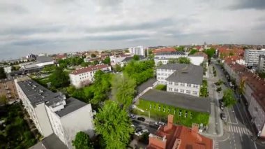 Video bir şehir caddesinin hava görüntüsüyle başlıyor. Cadde, çoğu karmaşık detaylarla süslenmiş ve mansard çatıları olan tarihi binalarla dolu. Birkaç tane de var.