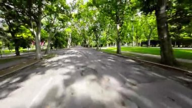 Video, Budapeşte, Macaristan 'daki Şehir Parkı manzarasıyla gösterime giriyor. Park yemyeşil ağaçlar ve çimlerle dolu ve arka planda bir göl var. Kamera daha sonra sağa döner.