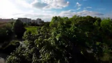 Bu, Polonya 'nın Opole kentindeki güzel bir yeşil parkın videosu. Park yemyeşil ağaçlar, yeşil çimenler ve renkli çiçeklerle dolu. Aynı zamanda park boyunca birkaç bank ve patika var.