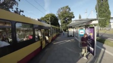 Varşova, Polonya 'da bir tramvay yolculuğunun birinci şahıs bakış açısı videosu. Video, tramvayın önünden çekiliyor ve sürücülere şehir sokaklarını, binaları ve insanları gösteriyor. Video.