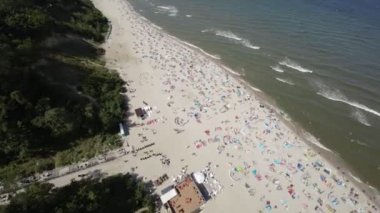 Bu hava görüntülerinde Polonya 'daki çarpıcı Jastrzebia Gora plajı doğal güzelliğini ve canlı atmosferini yansıtıyor. Video sahilin nefes kesici panoramik çekimiyle başlıyor.