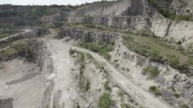 Video, kayalık bir taş ocağının büyüleyici bir hava görüntüsünü sunuyor. Taş ocağı milyonlarca yıldır oluşmuş sivri kayalarla doludur. Taş ocağı kaya için popüler bir yerdir.