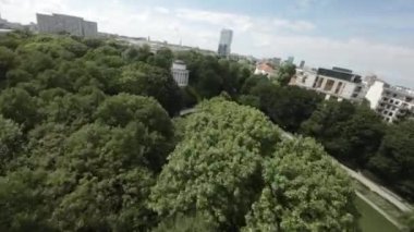 Video, Polonya 'nın Varşova kentindeki Azienki Parkı' nın kuş bakışı görüntüsüyle başlıyor. Park, ortasında büyük bir gölet bulunan yemyeşil ve yemyeşildir. Parkta yürüyen ve dinlenen birkaç kişi var. Şey...