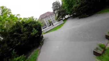 Polonya 'nın Opole kentindeki bir parkta ziyaretçiler için geniş yeşil çimenler, olgun ağaçlar ve banklar bulunmaktadır..