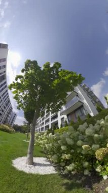 Bu video, verimli ve bakımlı bahçeleri olan güzel ve modern apartman binalarını gösteriyor. Video, sizi çeşitli açık alanlara götüren sanal bir tur.