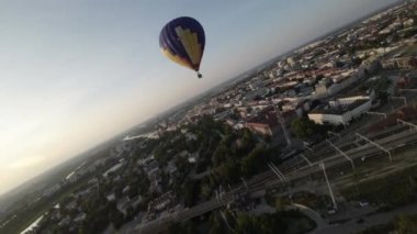 Çarpıcı bir şehir manzarasında zarafetle süzülürken heyecan verici bir sıcak hava balonu macerasına binin. Büyüleyici görüntüler, aşağıdaki şehir manzarasını oluşturan balonların yükselişini yakalıyor.