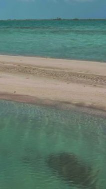 Bu büyüleyici drone görüntüsü sizi tenha bir tropik kum yığınına doğru büyüleyici bir yolculuğa çıkarıyor. El değmemiş beyaz kumlar ve kristal berraklığında turkuaz sular nefes kesici bir manzara yaratır.