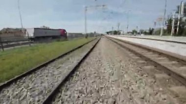 Bir tren istasyonunun videosu. Video rayları, platformu ve istasyon binasını gösteriyor. Uzakta bir tren var..