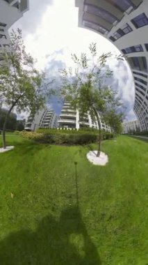 Bu büyüleyici 4K doğa yürüyüşü videosunda büyüleyici yeşil bir avluda sakin bir gezinti yapın. Modern apartman binalarıyla çevrili olan avlu, düzgünce hazırlanmış sakin bir vaha.