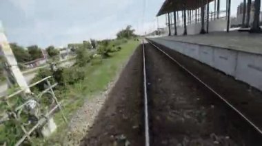 Bir tren istasyonunun videosu. Video rayları, platformu ve istasyon binasını gösteriyor. Uzakta bir tren var..