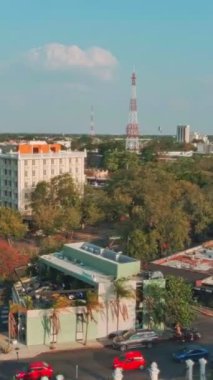 Bu büyüleyici video, modern yapıların tarihsel yapılarla uyum içinde yaşadığı canlı bir şehir manzarasının kuşbakışı görüntüsünü sunuyor. Kalabalık sokaklar yemyeşil ağaçlarla süslenir.