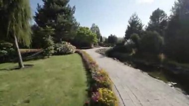 Video, güzel bir bahçenin yavaş ve rahatlatıcı bir turu. Sergide çeşitli çiçekler, ağaçlar ve bir gölet yer alıyor. Bahçe iyi bakılmış ve bitkilerin hepsi çiçek açmış. Bu video...