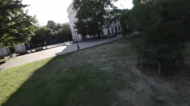 Bu, parkta yürüyüşün birinci şahıs bakış açısı videosu. Video güneşli bir günde çekildi ve park yemyeşil yemyeşil. Ağaçlar uzun ve yapraklar canlı bir yeşildir. Şey...