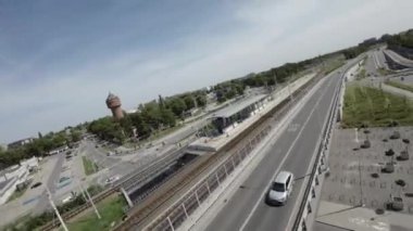 Video, yoğun bir kavşağın hava görüntüsüyle başlıyor. Kamera, iki yöne de giden araba ve otobüslerin olduğu bir caddeyi gösteriyor. Arka planda birkaç yüksek bina var.