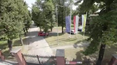 Video, Avrupa Komisyonu ve üye ülkelerin bayraklarını gösteriyor. Video, binanın önünde dalgalanan bayrakların statik görüntüsü. Bayraklar farklı boyutlarda ve şekillerde.