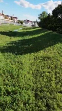 Bu büyüleyici video sizi sakin bir yolculuğa çıkarıyor. Resimli nehir kıyısı boyunca. Huzur ortamı, uzun otların rüzgarda hafifçe sallandığı yemyeşil bir ortam ile karakterize edilir. Kristal