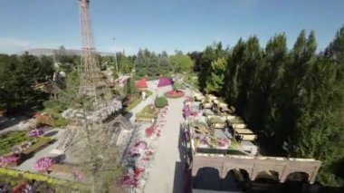 Video, Eyfel Kulesi 'nin bir kopyasının yer aldığı titizlikle döşenmiş bir bahçenin havadan görüntüsüyle açılıyor. Kule renkli çiçek sepetleriyle süslenmiştir.