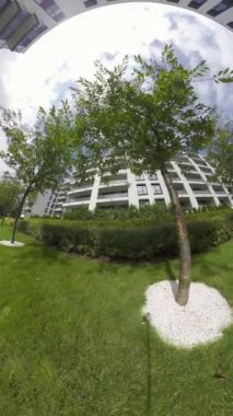 Bu video, yemyeşil bir avlusu olan modern bir apartman kompleksi için sanal bir tur sağlıyor. Kompleks ağaçlarla çevrili ve yüzme havuzu, fitness gibi çeşitli konforlara sahip.