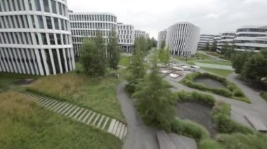 Bu video, manzaralı bahçeler ve su özelliklerinin yer aldığı, huzurlu ve görsel olarak memnun edici bir çalışma ortamı sağlayan modern bir ofis parkını gösteriyor. Park çağdaş bir şekilde tasarlandı.