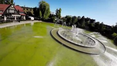 Polonya 'nın Opole kentindeki FPV uçuşunun birinci şahıs görüntüsü. Uçuş, kameranın havuz ve çeşme üzerinde uçtuğu parkta başlıyor. Daha sonra şehir sokaklarında devam eder.