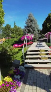 Bu video sizi canlı çiçekler ve yemyeşil çiçeklerle dolu çarpıcı bir bahçede sakinleştirici bir yürüyüşe çıkarıyor. Bahçede güller, laleler ve zambaklar da dahil olmak üzere çeşitli renkli bitkiler yer alıyor.