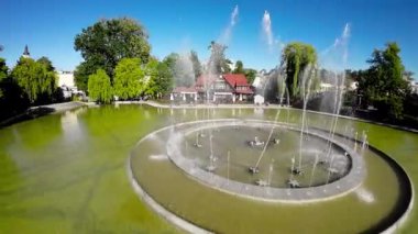 Video, Polonya 'nın Opole kentindeki bir çeşmenin görüntüsüyle başlıyor. Çeşme bir parkta yer almaktadır ve ağaçlar ve bir geçitle çevrilidir. Çeşmedeki su yeşil ve orada.