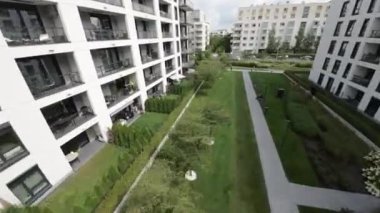 Videoda birkaç apartmanı olan bir yerleşim alanı var. Binalar modern ve yeşil bahçeler, oyun alanları ve yeraltı otoparkı gibi pek çok konfora sahipler. Bölge iyi durumda.