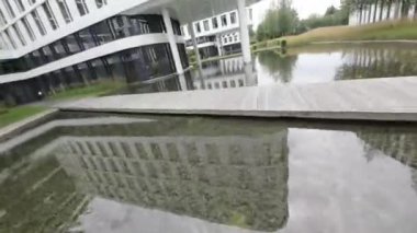 Video, Varşova, Polonya 'daki Varşova Spire ofis binalarının görüntüsüyle açılıyor. Binalar modern ve eşsiz bir tasarımı var. Video daha sonra binaların çatılarını gösteriyor ki,