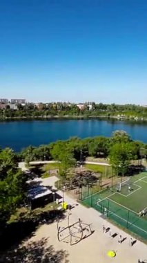Bu nefes kesen hava turu sizi çarpıcı bir park ve göl üzerinde süzülerek yemyeşil, sakin sulara ve manzaralara kuşbakışı bir bakış açısı sunuyor. Video şu şekilde başlıyor: