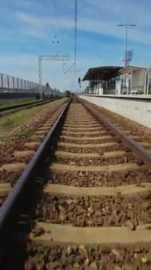 Çimenli bir arazide bir tren rayının videosu. Video, raylar boyunca yürüyen bir kişinin perspektifinden çekildi. İzler metal raylar ve tahta bağlardan yapılmış. Çimler yeşil.