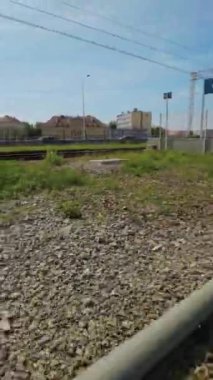 Bu video küçük bir kasabadaki tren yolunu gösteriyor. Video, raylar boyunca yürüyen bir kişinin perspektifinden çekildi. İzler çelikten yapılmış ve etrafı çakıllarla çevrili. Video.