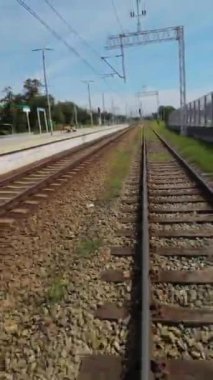 Yoğun bir şehirden geçen bir trenin penceresinden çekilmiş bir video. Video tren raylarını, etrafındaki binaları ve yoldaki arabaları gösteriyor. Video, bu videonun...