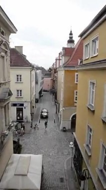Bu video sizi tuhaf bir Avrupa şehrinde sessiz bir sokakta sanal bir gezintiye çıkarıyor. Dar sokak kırmızı tuğladan yapılmıştır ve büyüleyici eski binalarla doludur. Birkaç ağaç gölgelik sağlar.