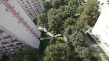 Bu büyüleyici hava videosu çarpıcı bir şehir manzarası sergiliyor. Yüksek apartman binaları yemyeşil alanlar arasında yüksek duruyor. Video şehrin nefes kesici panoramik çekimiyle açılıyor.