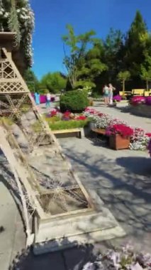 Bu büyüleyici video, renkli çiçeklerin arasında duran ikonik Eyfel Kulesi 'nin titizlikle hazırlanmış bir kopyasını sergiliyor. Kulelerin karmaşık metal iskeleti süslenmiş.