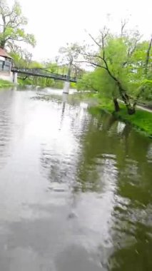Kendini doğanın sükunetine bırak. Huzurlu bir nehrin güzel bir parkta akışının bu büyüleyici videosuyla. Suyun tekneye hafifçe dokunması rahatlatıcı bir etki yaratır.