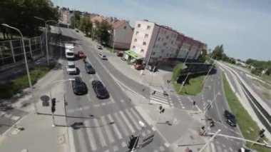 Video işlek bir kavşağın görüntüsüyle başlıyor. Yolda arabalar var ve yolun sağ tarafında da bir bisikletçi yol alıyor. Bisikletçi kask takıyor ve aynı kask takıyor.