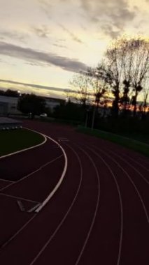 Bir İHA pilotunun gün batımında pistte yol alırken FPV yarışının heyecanını yaşayın. İnsansız hava aracının engelleri aşıp, çarpıcı manzarayı yakalayışını ve eşsiz bir bakış açısı sunuşunu izleyin.