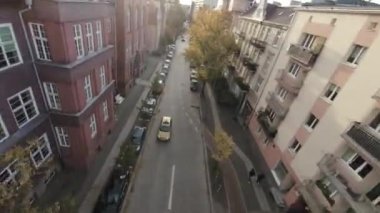 Video, sonbahar ağaçları ve binaları olan geniş bir caddenin görüntüsüyle başlıyor. Kamera caddede uçuyor, güzel sonbahar renklerini gösteriyor. Video FPV birinci şahıs görünümünde.