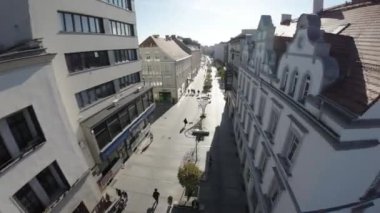 Video, Avrupa 'da bir yaya caddesinden geçen bir FPV Birinci Şahıs Görünümlü insansız hava aracı. İnsansız hava aracı caddede uçuyor, dükkanların, restoranların ve kafelerin önünden geçiyor. Video güneşli bir havada çekildi.