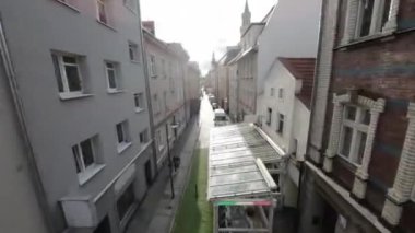 Güneşli bir günde eski şehir merkezinde küçük dükkanları olan eski tarihi yerleşim yerleri arasında dar bir kaldırım taşı caddesi. Sokaklar renkli binalarla dolu.